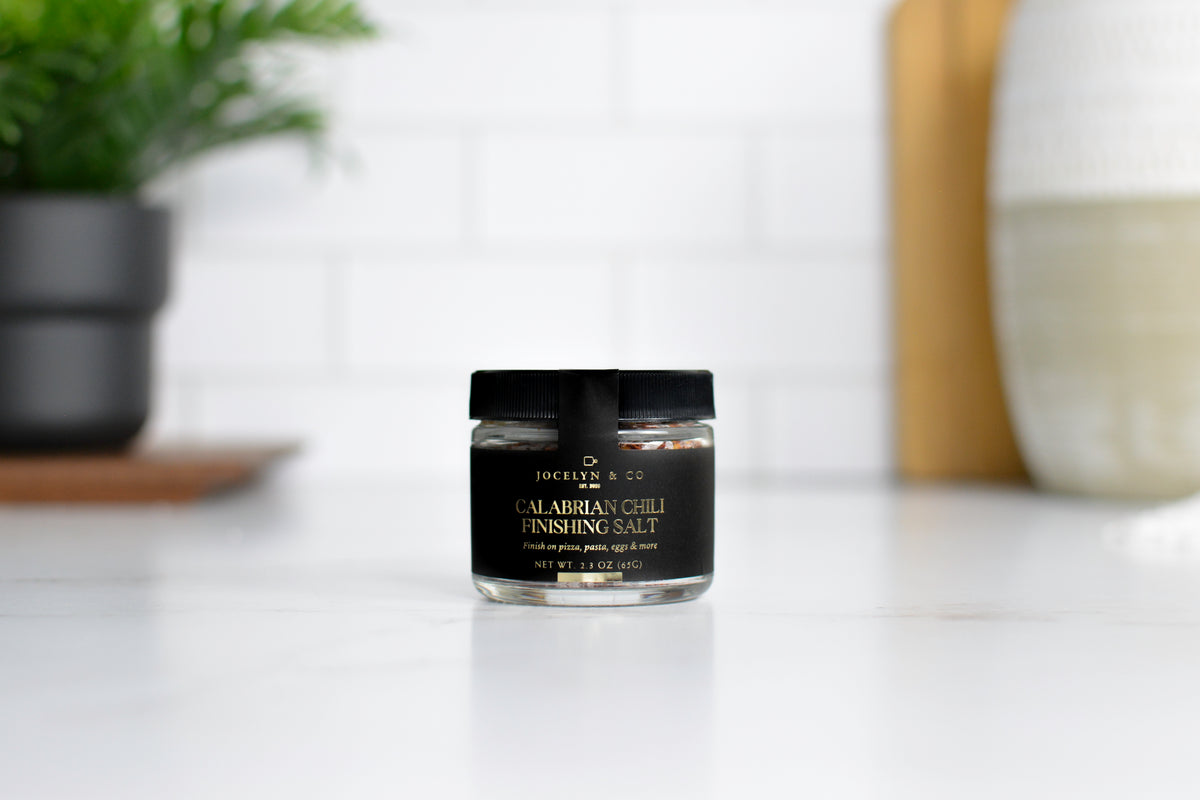 Black & Gold Calabrian Chili Finishing Salt in a black-lidded glass jar