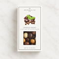 Jocelyn & Co. Chocolate Covered Espresso Beans box, centered on pale marble with its chocolate assortment visible through the window