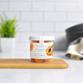 Jocelyn & Co. Mediterranean Apricots Jar, upright on a wooden board in a softly lit kitchen setting
