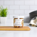Jocelyn & Co. Mixed Nuts Jar, upright on a wooden board in a softly lit kitchen setting