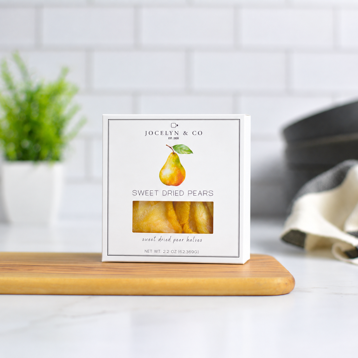 Jocelyn & Co. Sweet Dried Pears, upright on a wooden board in a softly lit kitchen setting