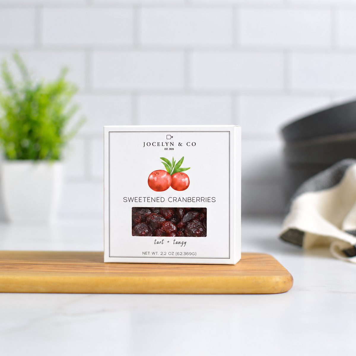 Jocelyn & Co. Sweetened Cranberries, upright on a wooden board in a softly lit kitchen setting
