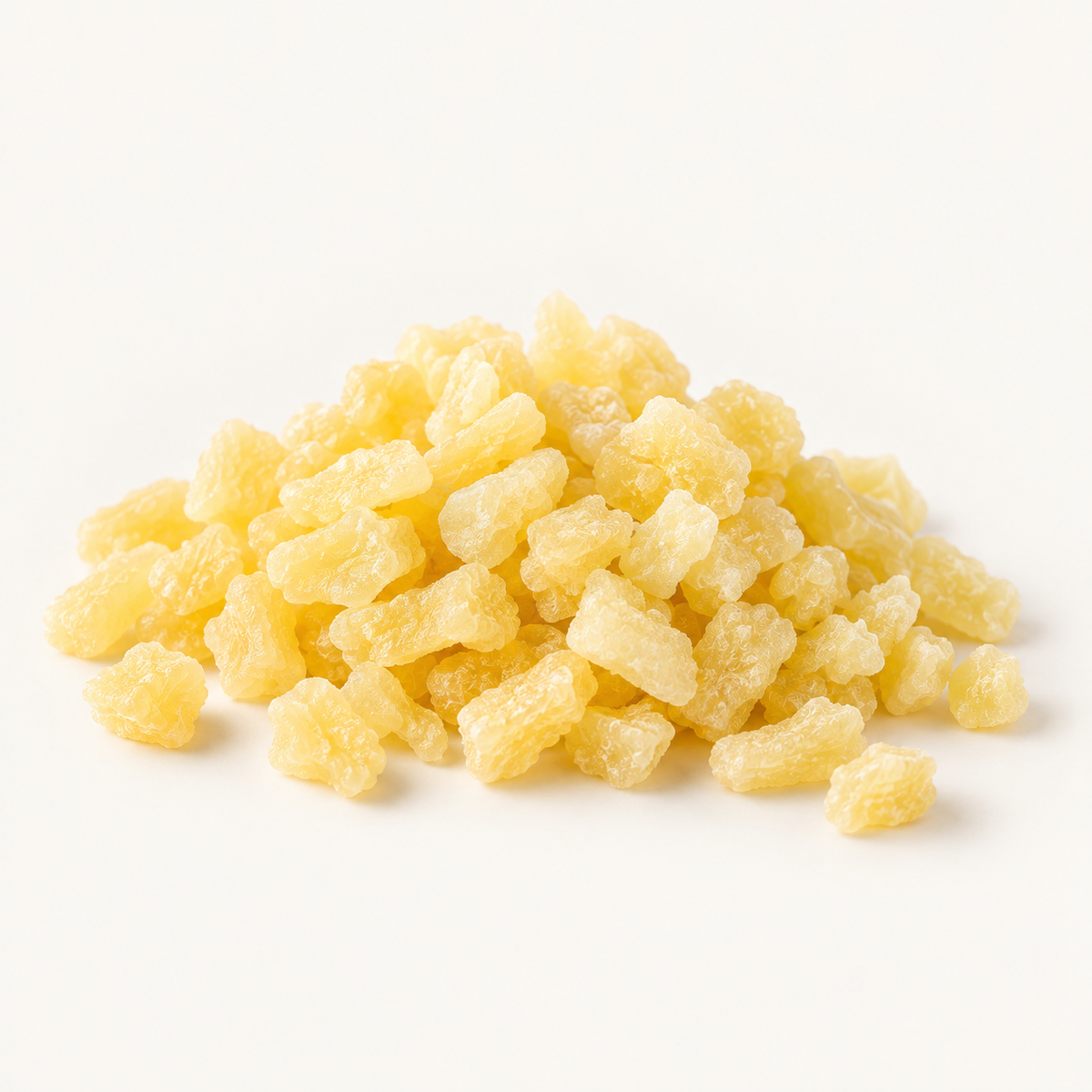 Small diced dried pineapple, styled as a small pile on warm ivory