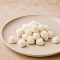 Irregular white nonpareil-coated Champagne Bubbles on a cream ceramic plate